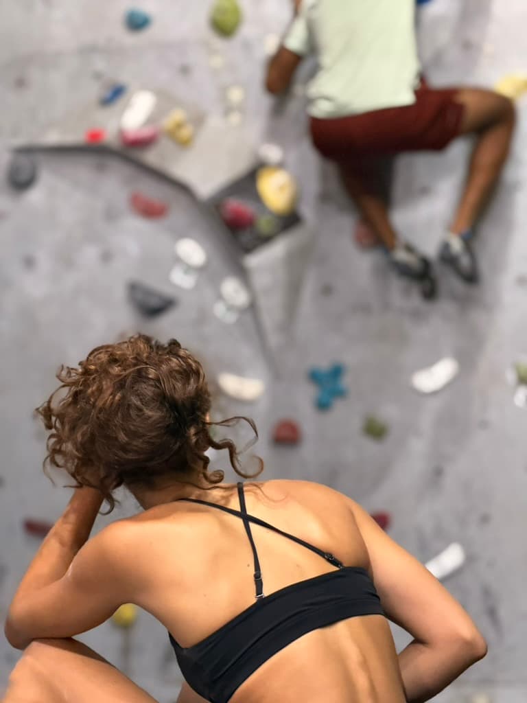 Climber in the foreground watching another person on an indoor wall